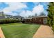 Backyard featuring an artificial turf lawn, covered patio, and brick house under a blue sky at 1386 S Garfield St, Denver, CO 80210