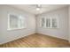A minimalist bedroom is bright with natural light from its two large windows and features hardwood floors at 1386 S Garfield St, Denver, CO 80210