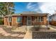 Charming brick home featuring a covered front porch and well-maintained landscaping at 1386 S Garfield St, Denver, CO 80210