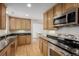 Bright kitchen features stainless steel appliances, wooden cabinets, granite countertops, and hardwood floors at 1386 S Garfield St, Denver, CO 80210