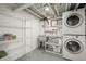 This laundry room has upper shelving and a utility sink and stackable washer and dryer at 1386 S Garfield St, Denver, CO 80210