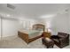 Spacious main bedroom featuring plush carpet, a queen bed, and a leather armchair and ottoman at 1386 S Garfield St, Denver, CO 80210