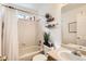 Well-lit bathroom featuring a shower over tub, decorative shelving, and modern fixtures at 2116 W 101St Cir, Thornton, CO 80260