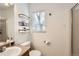 Clean bathroom with a single sink vanity, sleek shelving, a window and toilet at 2116 W 101St Cir, Thornton, CO 80260