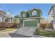 Green two-story home features a two-car garage and front yard with mature landscaping at 2116 W 101St Cir, Thornton, CO 80260