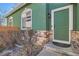 Inviting entrance with a green front door, stone accents, and manicured landscaping at 2116 W 101St Cir, Thornton, CO 80260
