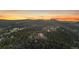 Breathtaking aerial view of home surrounded by dense forest, with mountains in the distance at sunset at 23007 Big Game Trl, Conifer, CO 80433