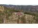 Aerial view of a secluded home nestled in a lush green mountain setting with mature trees at 23007 Big Game Trl, Conifer, CO 80433