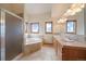 Bright bathroom featuring a tiled shower, soaking tub, dual vanities, and windows with mountain views at 23007 Big Game Trl, Conifer, CO 80433