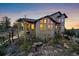 Stunning exterior view of a multi-story home, complemented by mature trees and natural rock outcroppings at 23007 Big Game Trl, Conifer, CO 80433