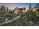 Charming home featuring a stone facade, wood accents, and a stepped walkway surrounded by lush greenery at 23007 Big Game Trl, Conifer, CO 80433
