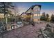 Beautiful home exterior with outdoor kitchen, fire pit and custom flagstone patio at dusk at 23007 Big Game Trl, Conifer, CO 80433