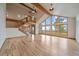 Bright living room with hardwood floors, vaulted ceilings, exposed beams, and large windows with scenic views at 23007 Big Game Trl, Conifer, CO 80433