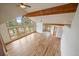 Open living room with wood beam ceiling, large windows, and light hardwood floors offering mountain views at 23007 Big Game Trl, Conifer, CO 80433