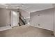 Carpeted living room with stairs and neutral tones, creating a blank canvas for personalization at 6358 E 121St Pl, Brighton, CO 80602