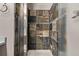 Walk-in shower featuring glass enclosure and unique stone tiled walls at 6358 E 121St Pl, Brighton, CO 80602