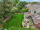 Aerial view of home featuring landscaped backyard, stone patio with fire pit, and lush greenery at 2974 E Otero Cir, Centennial, CO 80122