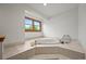 A luxurious tub is set within a tiled surround and a bright window overlooking the yard at 2974 E Otero Cir, Centennial, CO 80122