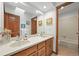 Bathroom featuring double sinks and vanity with wood cabinets for storage at 2974 E Otero Cir, Centennial, CO 80122