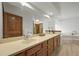 Bathroom featuring dual sinks, a large mirror, wood cabinets, and a soaking tub at 2974 E Otero Cir, Centennial, CO 80122