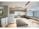 Well-lit kitchen with island, white cabinetry, and tile flooring at 1652 Egret Way, Superior, CO 80027