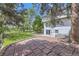 Spacious backyard featuring a brick patio, lush green lawn, and mature trees at 7792 Garrison Ct, Arvada, CO 80005
