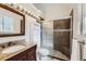 Bathroom featuring granite counters, tiled shower with sliding glass doors, and modern lighting, for a spa-like feel at 7792 Garrison Ct, Arvada, CO 80005