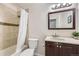 Bathroom featuring tiled shower, vanity with a light-colored countertop, and a traditional framed mirror at 7792 Garrison Ct, Arvada, CO 80005