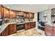 Kitchen featuring stone floors, wooden cabinets, stainless steel appliances, and open to the living room at 7792 Garrison Ct, Arvada, CO 80005