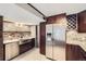Kitchen featuring stainless steel appliances, wood cabinetry, a farmhouse sink, and brick accents at 7792 Garrison Ct, Arvada, CO 80005