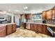 Well-lit kitchen featuring granite countertops, stainless steel appliances, and travertine floors at 7792 Garrison Ct, Arvada, CO 80005