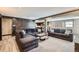 Comfortable living room with gray couches, brick accent wall, and access to the bar/kitchenette at 7792 Garrison Ct, Arvada, CO 80005
