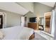 Well-lit main bedroom with vaulted ceiling, dresser, flatscreen, access to an ensuite bath, and sunny windows at 7792 Garrison Ct, Arvada, CO 80005