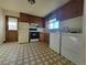 Functional kitchen featuring classic cabinetry, appliances and adjacent laundry area at 117 Valentine Ln, Longmont, CO 80501