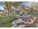 Landscaped backyard featuring a stone patio with a fire pit and mature trees, perfect for outdoor entertaining at 17067 Motsenbocker Way, Parker, CO 80134