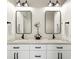 Dual vanity bathroom features black fixtures, granite countertops, and decorative mirrors with modern lighting at 17067 Motsenbocker Way, Parker, CO 80134