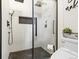 Modern bathroom featuring glass shower, shower head, with black tile flooring and fixtures at 17067 Motsenbocker Way, Parker, CO 80134