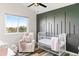 Charming Bedroom features a white crib, a comfortable chair, and a statement wall, creating a cozy and inviting space at 17067 Motsenbocker Way, Parker, CO 80134