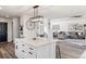 Bright open-concept kitchen with white cabinetry, stainless appliances, and eat-in island overlooks the living area at 17067 Motsenbocker Way, Parker, CO 80134