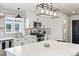 Modern kitchen featuring white cabinets, geometric backsplash, stainless steel appliances, and stylish light fixture at 17067 Motsenbocker Way, Parker, CO 80134