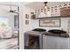 Well-organized laundry room featuring a modern washer and dryer set and decorative shelving at 17067 Motsenbocker Way, Parker, CO 80134