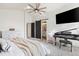 Bright primary bedroom featuring piano, tv, bed, barn door leading to a bathroom and neutral carpet at 17067 Motsenbocker Way, Parker, CO 80134