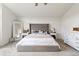 Spacious primary bedroom features a tufted headboard, a large bed with neutral bedding, and soft neutral carpet at 17067 Motsenbocker Way, Parker, CO 80134