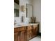 Bathroom vanity featuring double sinks, marble countertop, and wooden cabinets at 3 Carriage Brook Rd, Cherry Hills Village, CO 80121