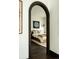 Inviting bedroom features hardwood floors, textured walls, and a doorway with a dark wood archway at 3 Carriage Brook Rd, Cherry Hills Village, CO 80121