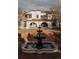 Elegant two-story home features a brick patio with tiered fountain and arched entryways at 3 Carriage Brook Rd, Cherry Hills Village, CO 80121