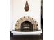 Unique arch fireplace with decorative brickwork and dark herringbone tile hearth at 3 Carriage Brook Rd, Cherry Hills Village, CO 80121