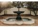 A large, tiered fountain sits centered on a brick patio, backed by a white fence and bare trees at 3 Carriage Brook Rd, Cherry Hills Village, CO 80121