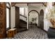 Inviting foyer featuring decorative tile flooring, dark wood stairs, and arched doorways at 3 Carriage Brook Rd, Cherry Hills Village, CO 80121