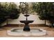 Captivating fountain surrounded by lush greenery and brickwork in this home's idyllic front yard at 3 Carriage Brook Rd, Cherry Hills Village, CO 80121